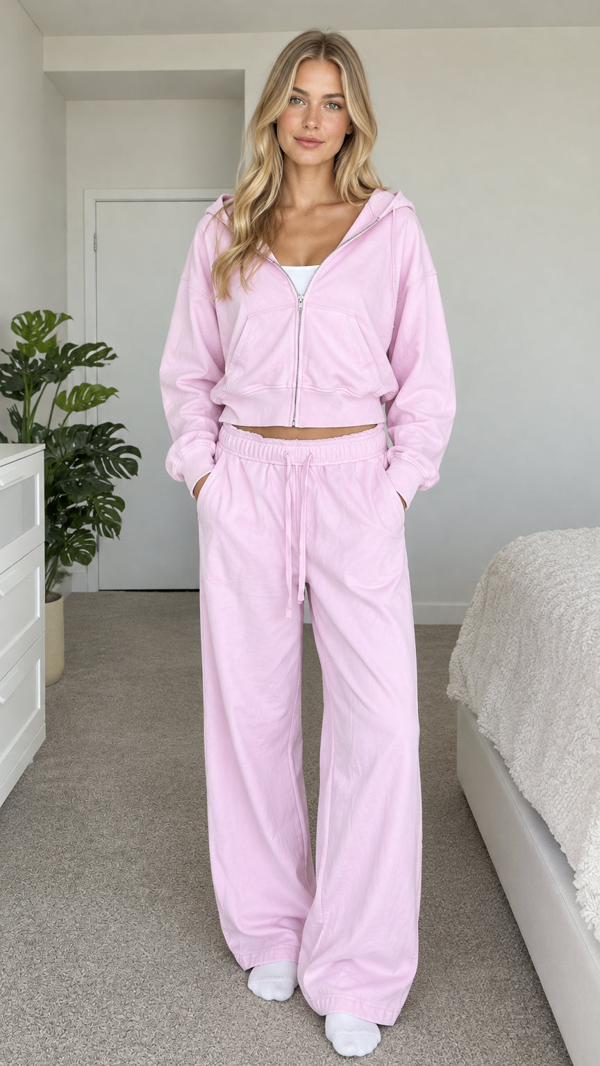 Model wearing light pink cropped zip hoodie and wide-leg sweatpants set front view