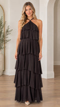 Front view of model wearing black halter neck tiered ruffle maxi dress