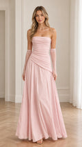 Front view of model in blush pink strapless ruched evening gown with matching sheer gloves