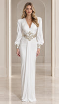 Front full-length view of model in white long sleeve evening maxi dress with gold waist embroidery