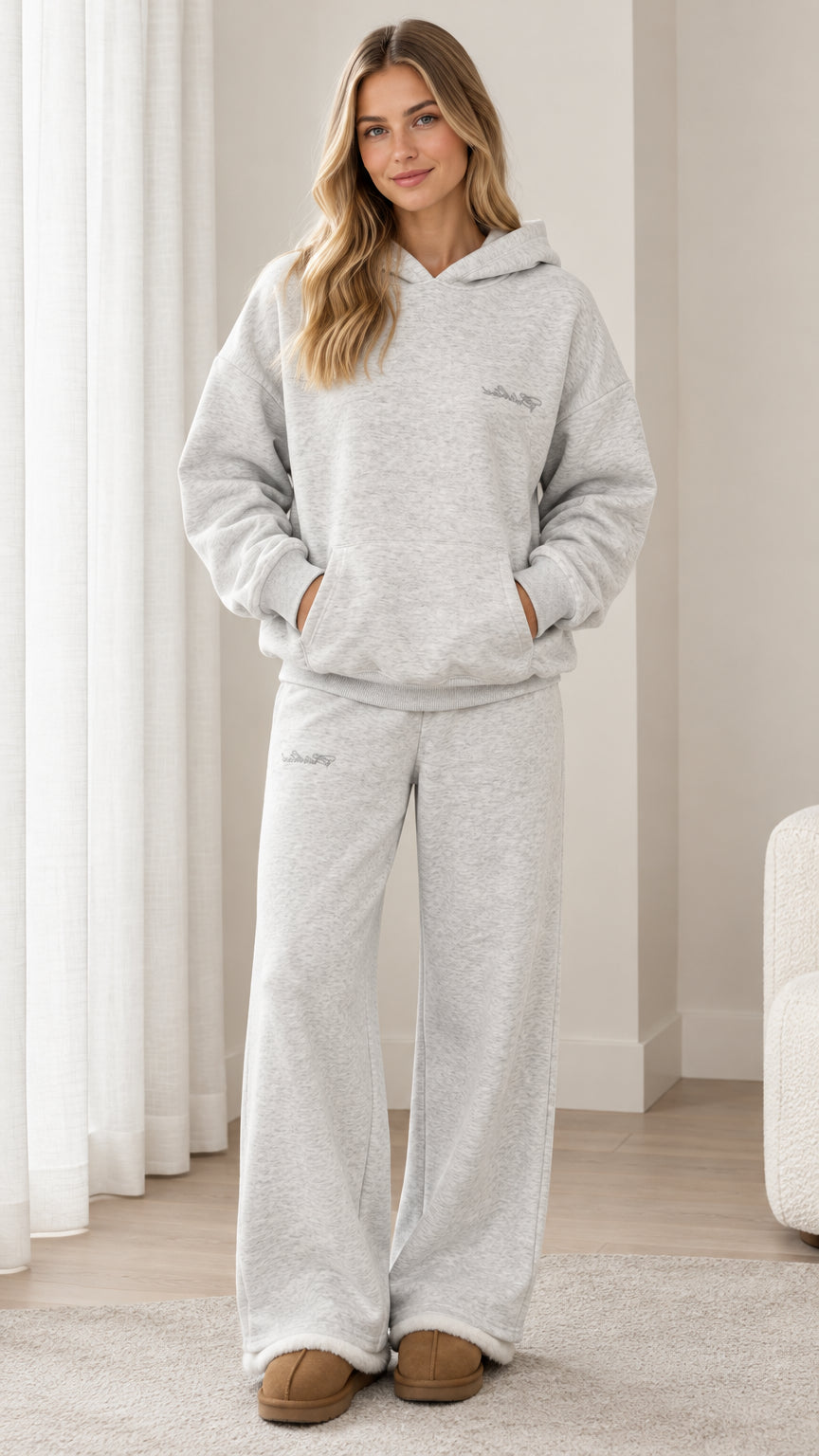 Front full-length view of woman wearing light heather grey oversized hoodie and wide-leg sweatpants set