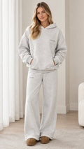 Front full-length view of woman wearing light heather grey oversized hoodie and wide-leg sweatpants set