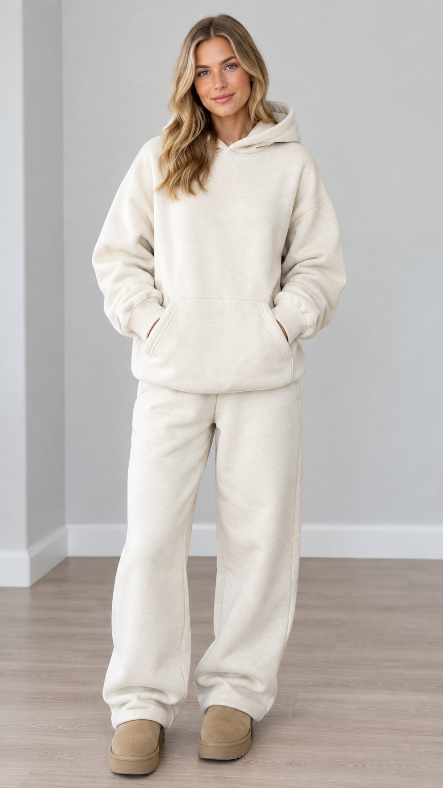 Front view of woman wearing cream oversized fleece hoodie and wide-leg sweatpants set