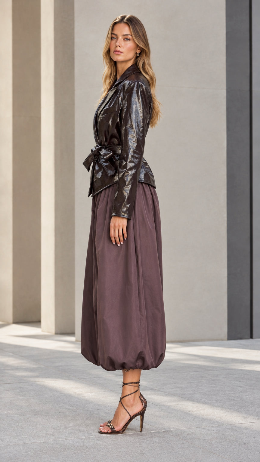 Side full-length view of chocolate brown glossy blazer and volumetric balloon pants two-piece set