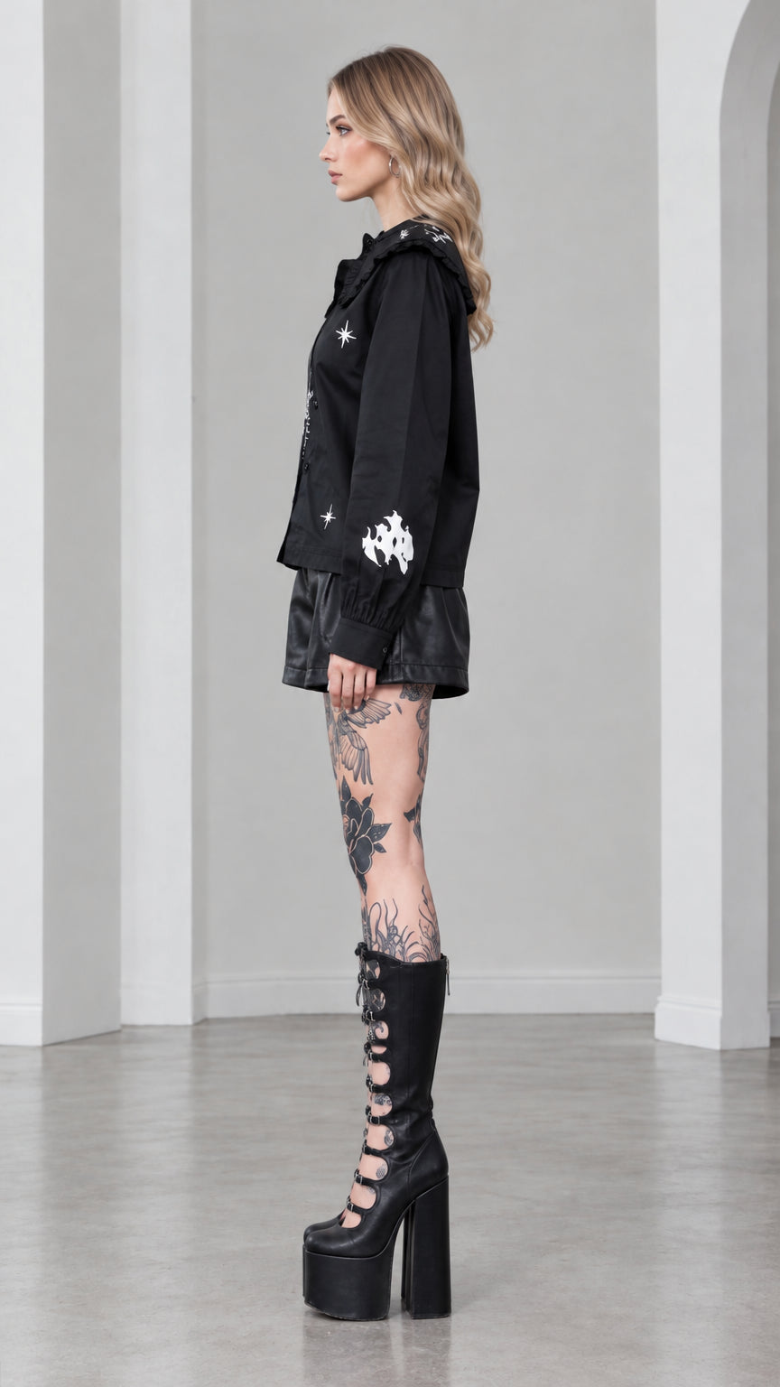Side profile view of model wearing black gothic castle print long sleeve blouse
