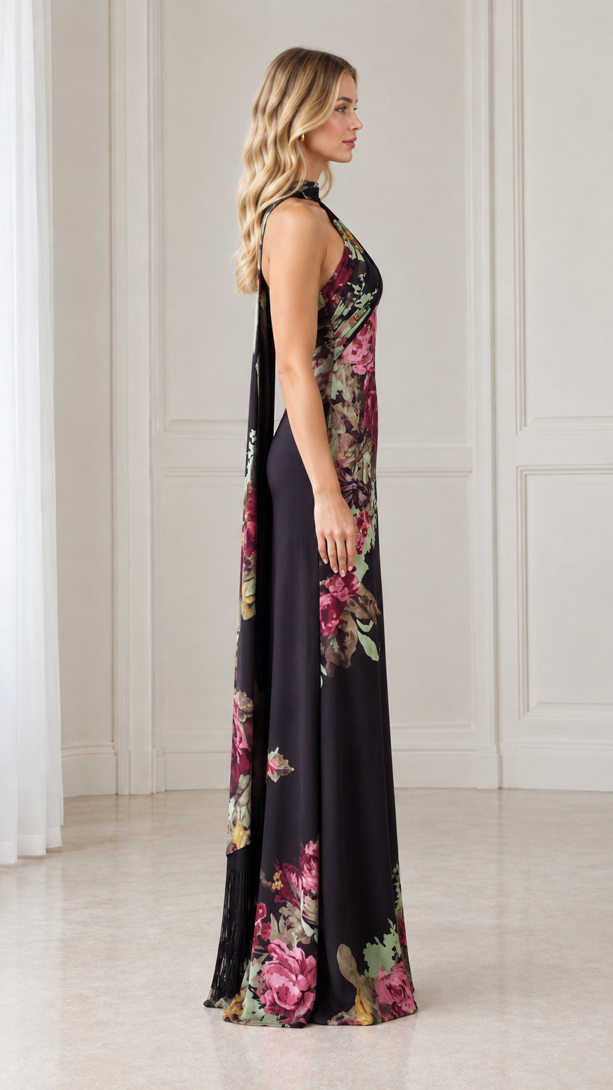 Side angle of model showcasing trailing back drape on black floral maxi dress