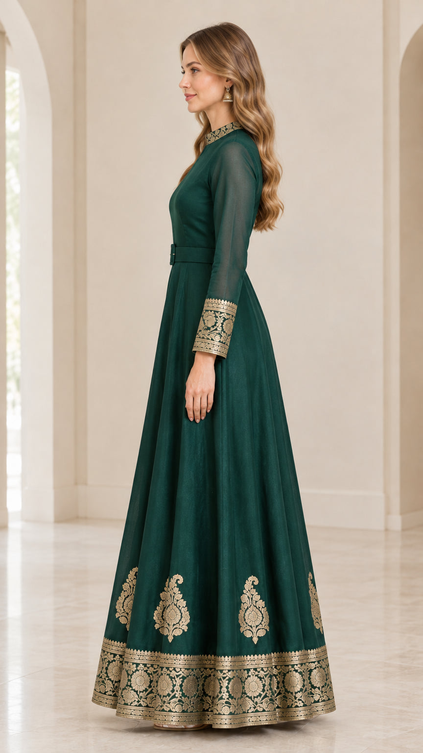 Side profile of emerald green belted maxi dress showing sweeping skirt and embroidered border
