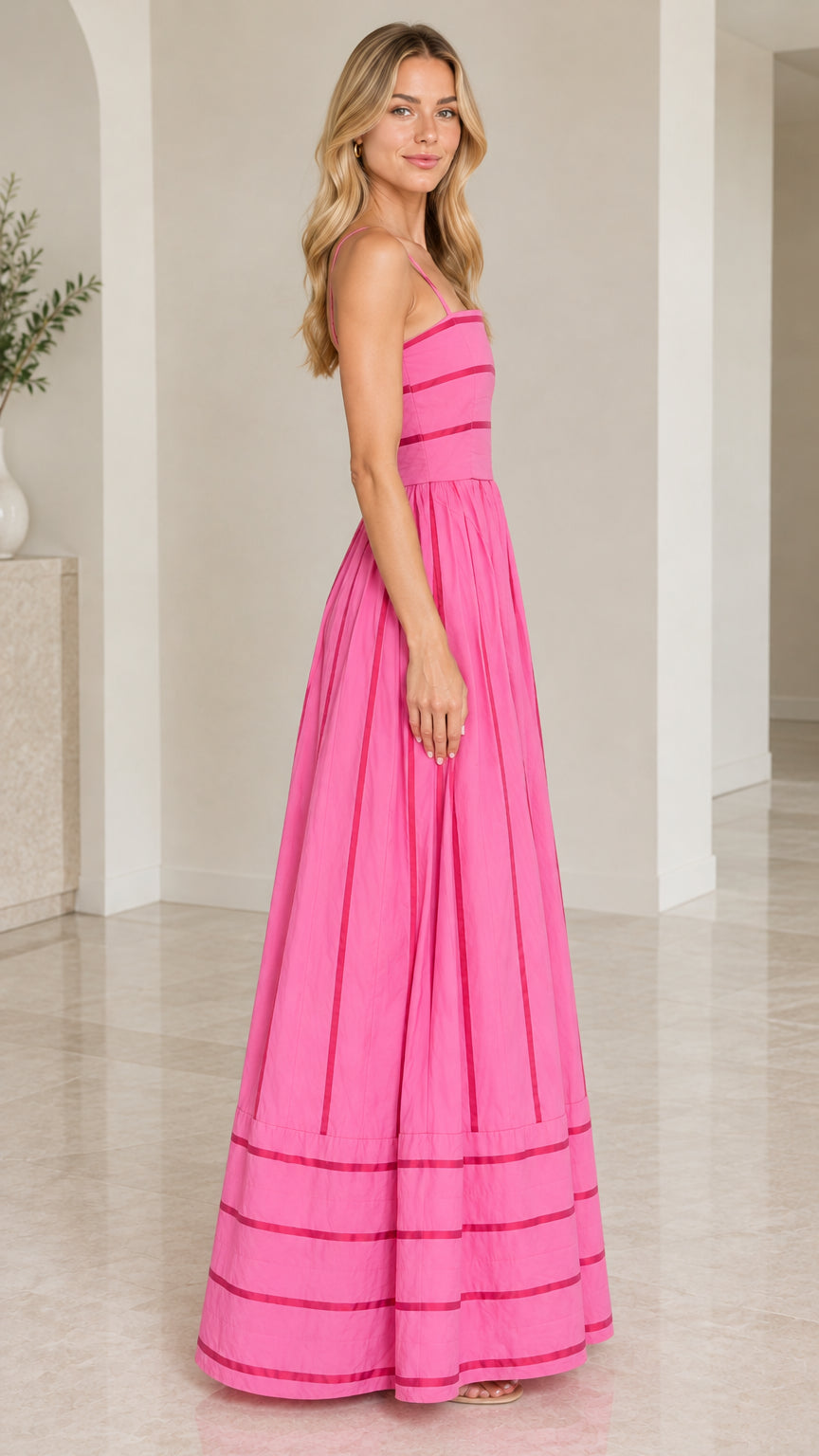 Side profile view of woman modeling hot pink ribbon detail sleeveless maxi dress