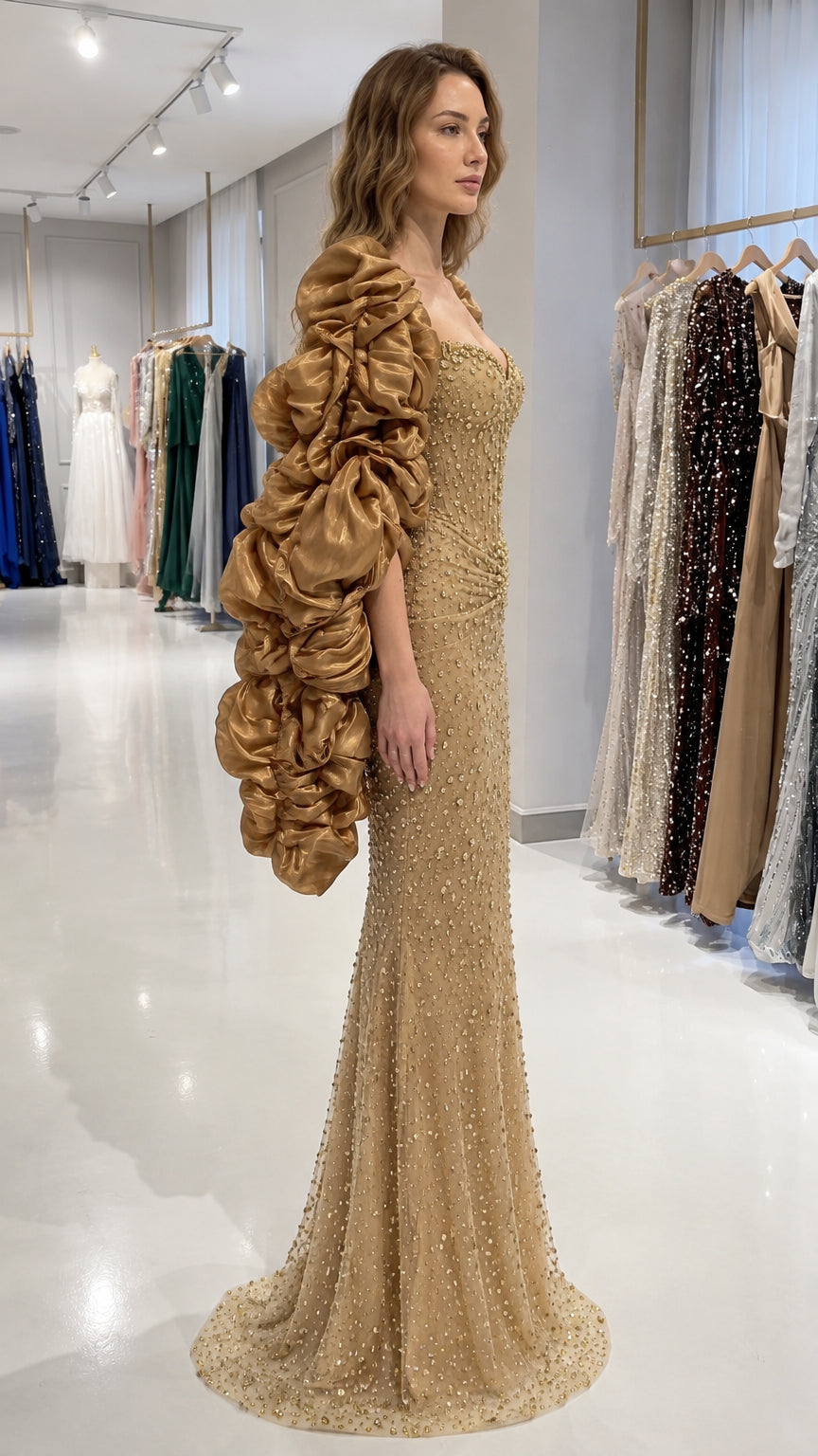 Side view of gold rhinestone embellished evening gown showing fitted silhouette and ruffled sleeves