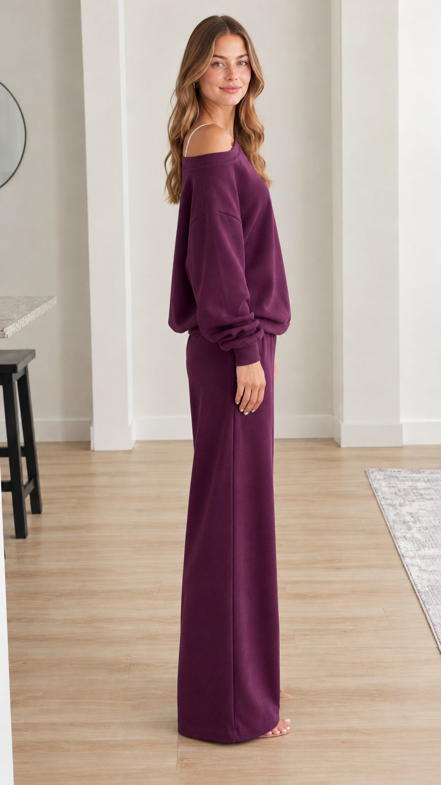 Side profile of model in plum two-piece loungewear set showing wide-leg pant drape