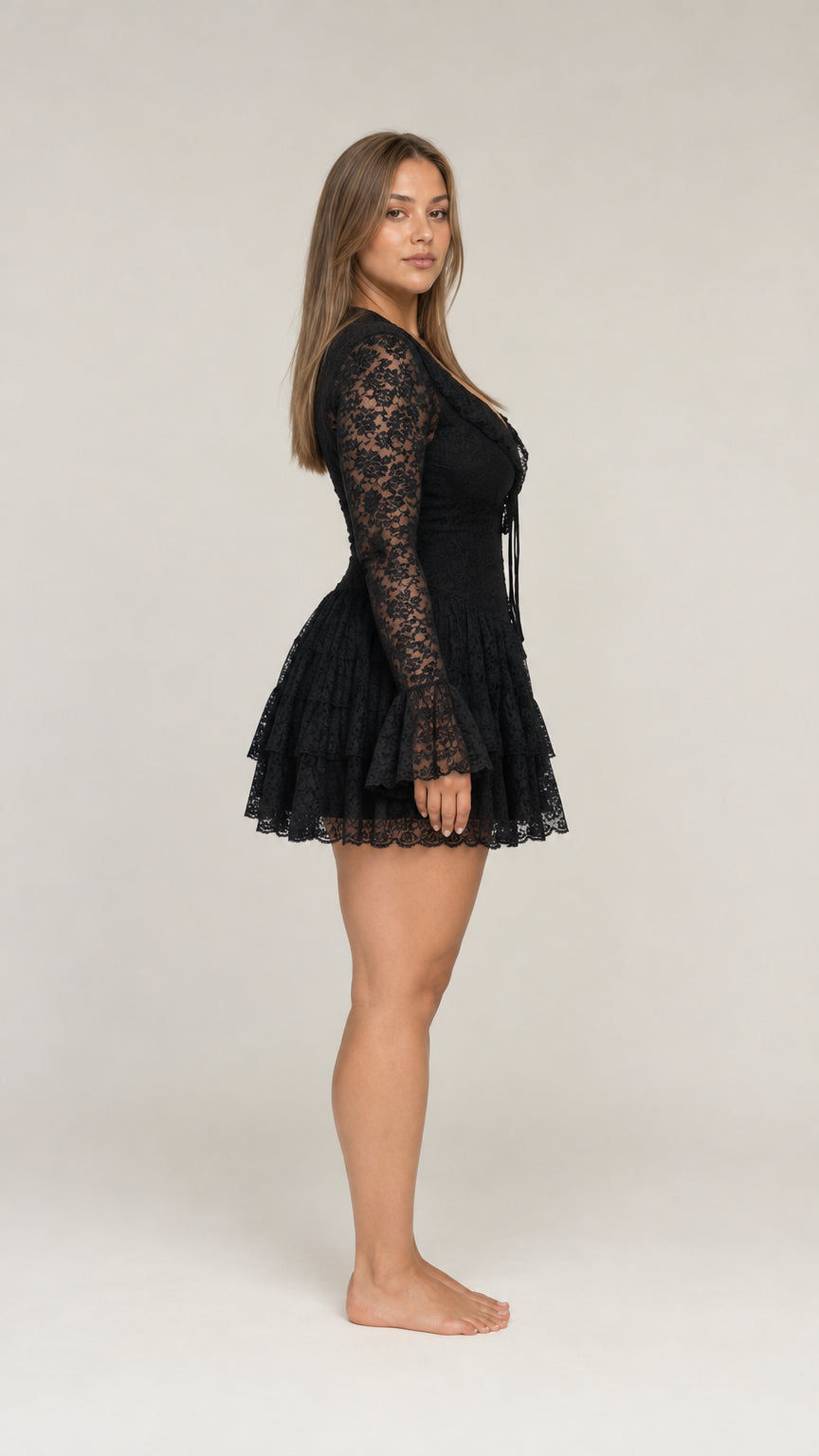 Side profile view of model wearing black floral lace bell sleeve mini dress