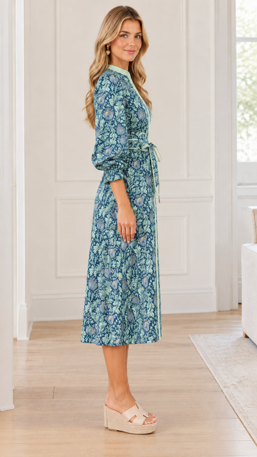 Side profile view of woman wearing teal blue botanical print midi dress