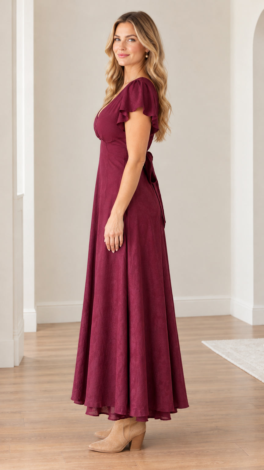 Side profile view of model wearing a burgundy A-line flutter sleeve maxi dress