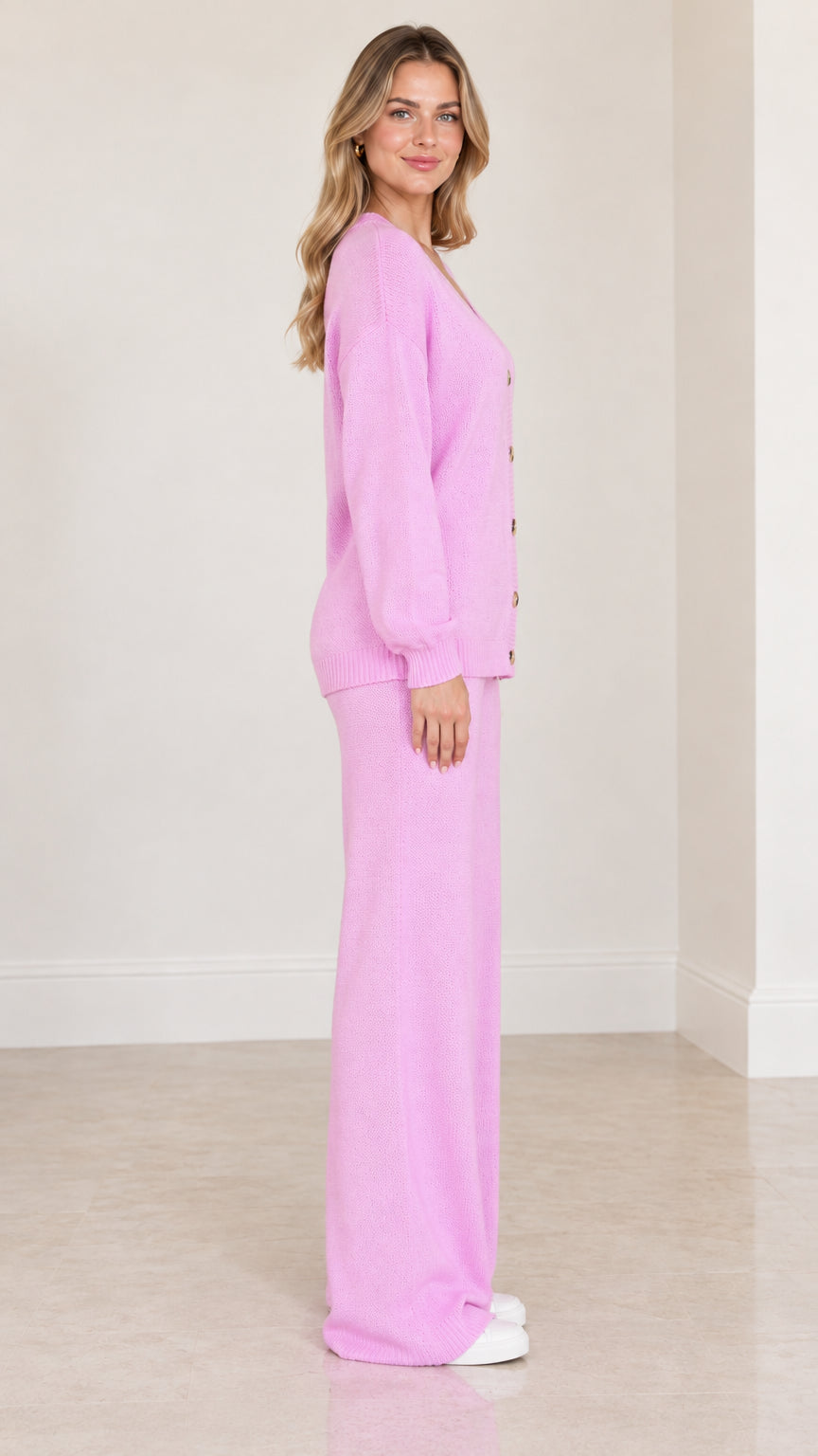 Side profile view of model in pink knit lounge cardigan and pants set