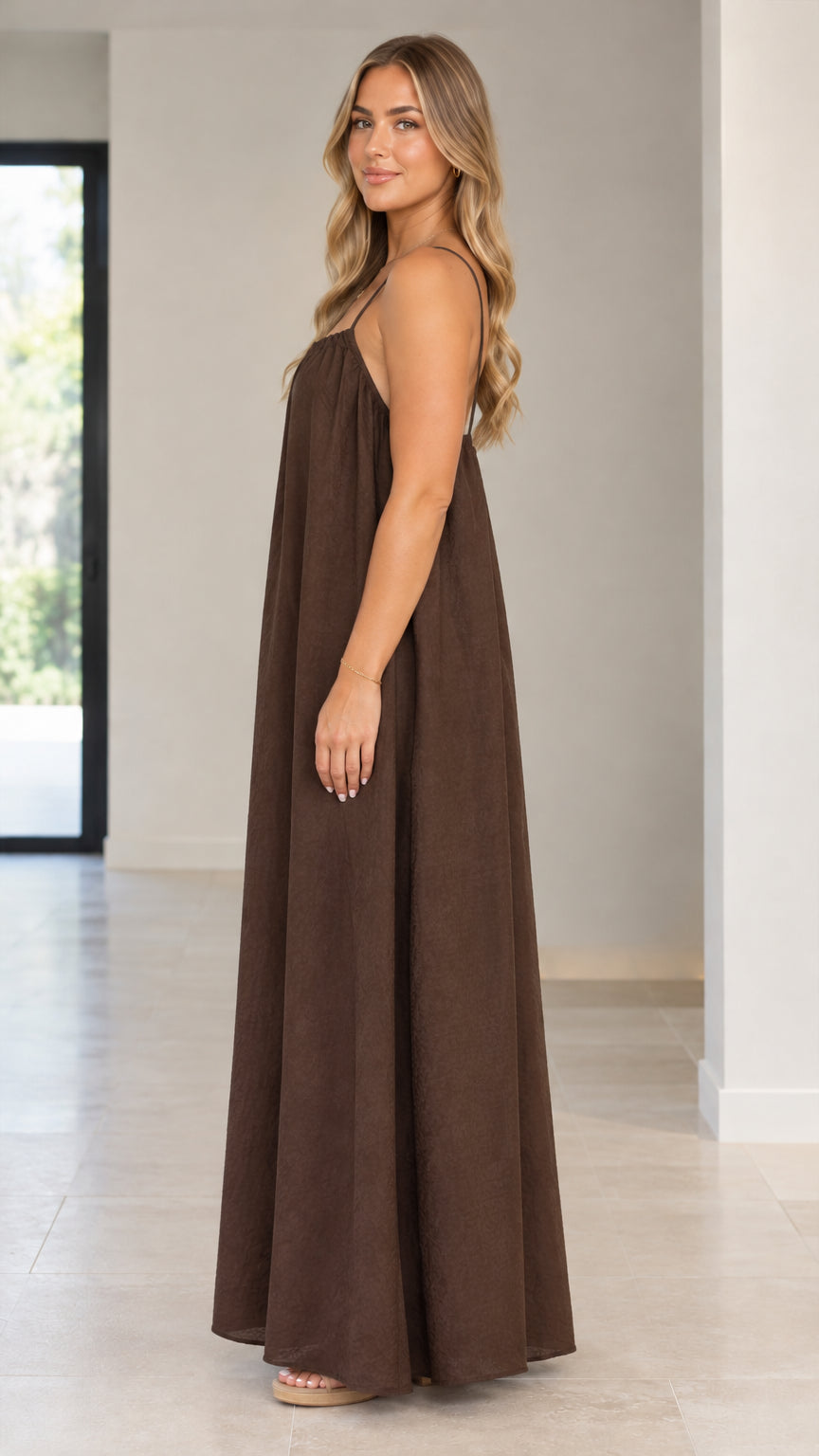Side profile view of model wearing a brown loose maxi-length cami jumpsuit