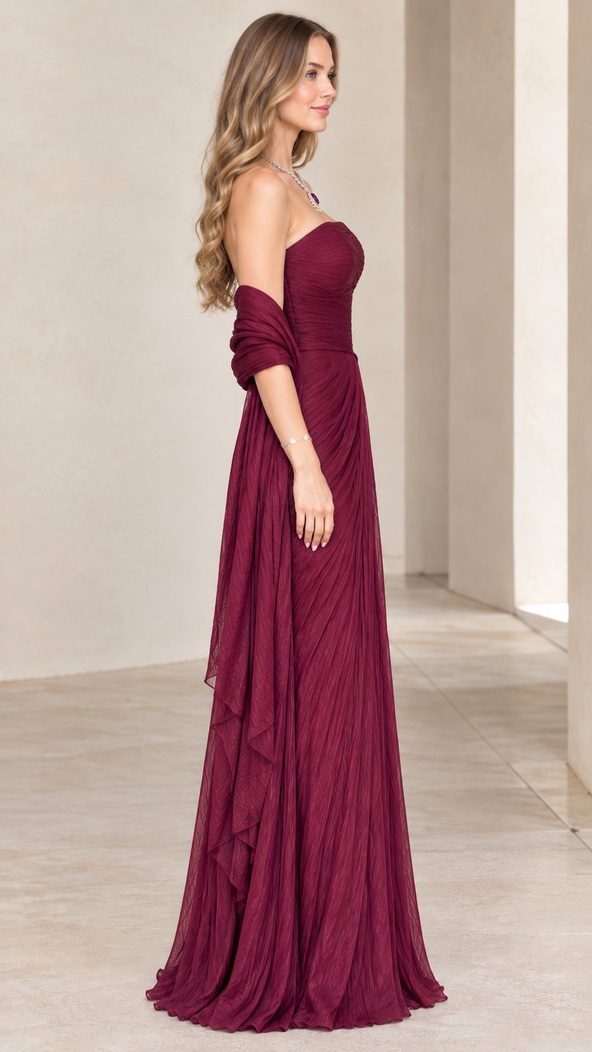 Side profile of burgundy strapless pleated maxi dress with draped wrap