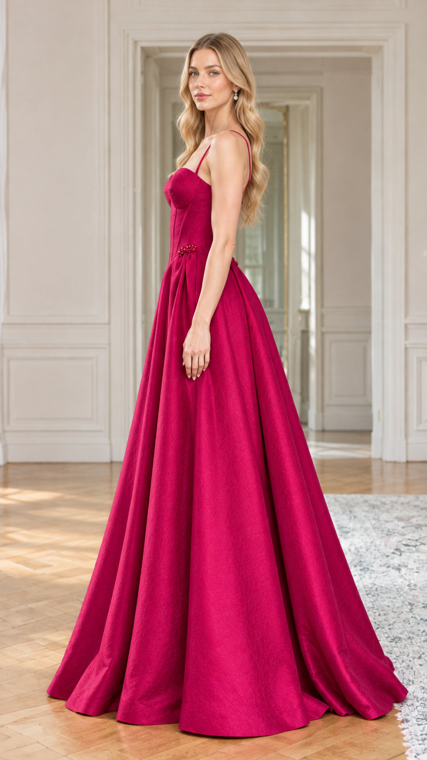 Side profile view of magenta sweetheart corset evening gown showing dramatic floor-length drape