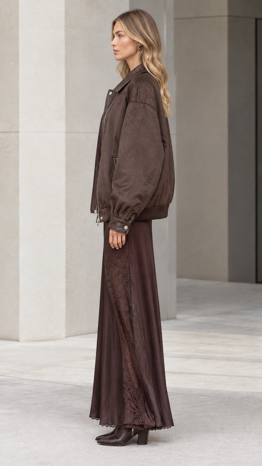 Side profile of model wearing brown bomber jacket and long slip dress