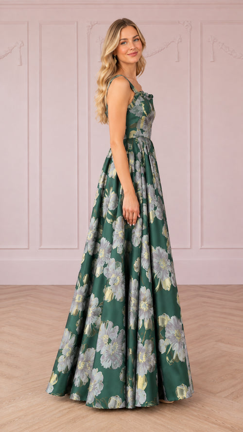 Side profile of woman modeling emerald green floral jacquard ballgown