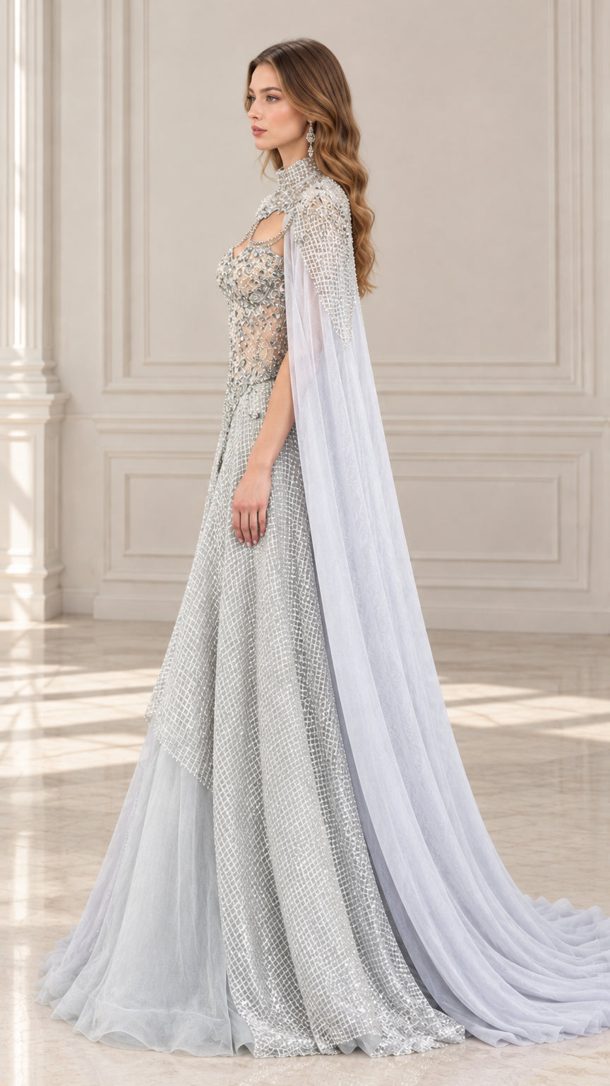 Side profile of silver gray embellished evening gown showing flowing tulle cape and train
