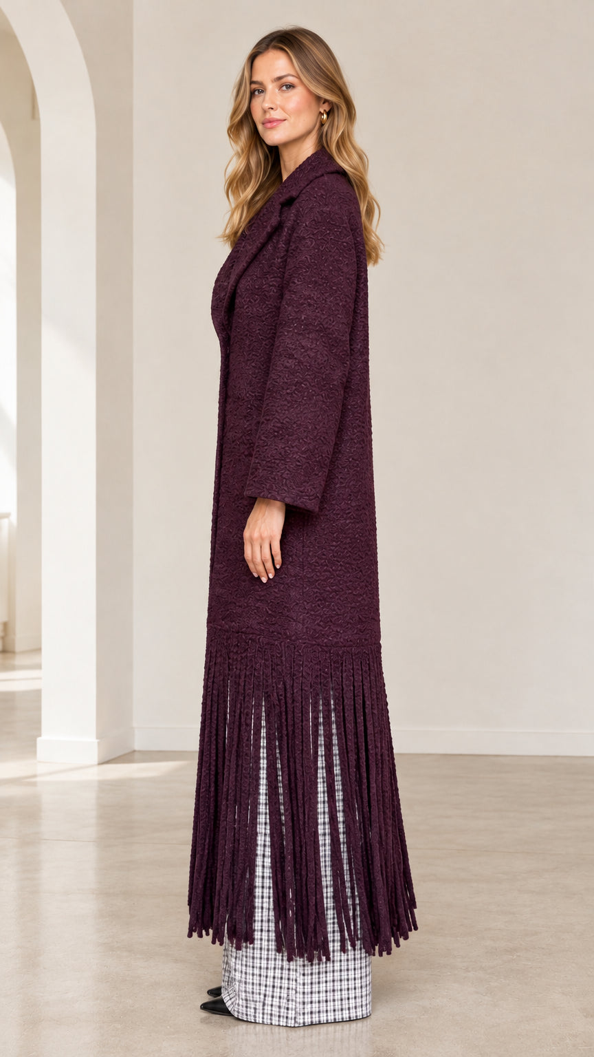 Side profile view of burgundy textured fringe maxi coat showing length and drape