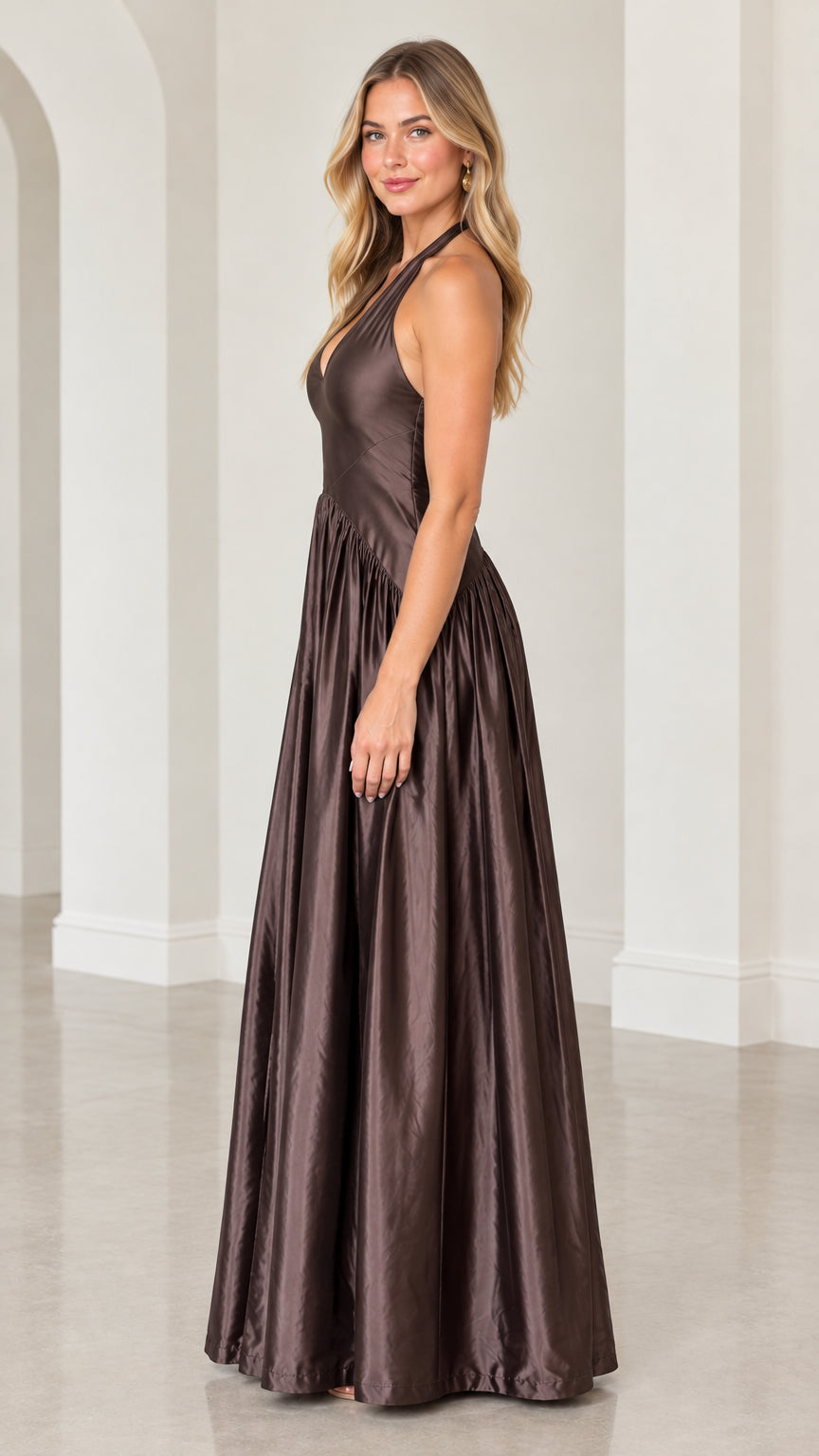 Side angle of model in chocolate brown halter satin formal dress showcasing fluid skirt drape
