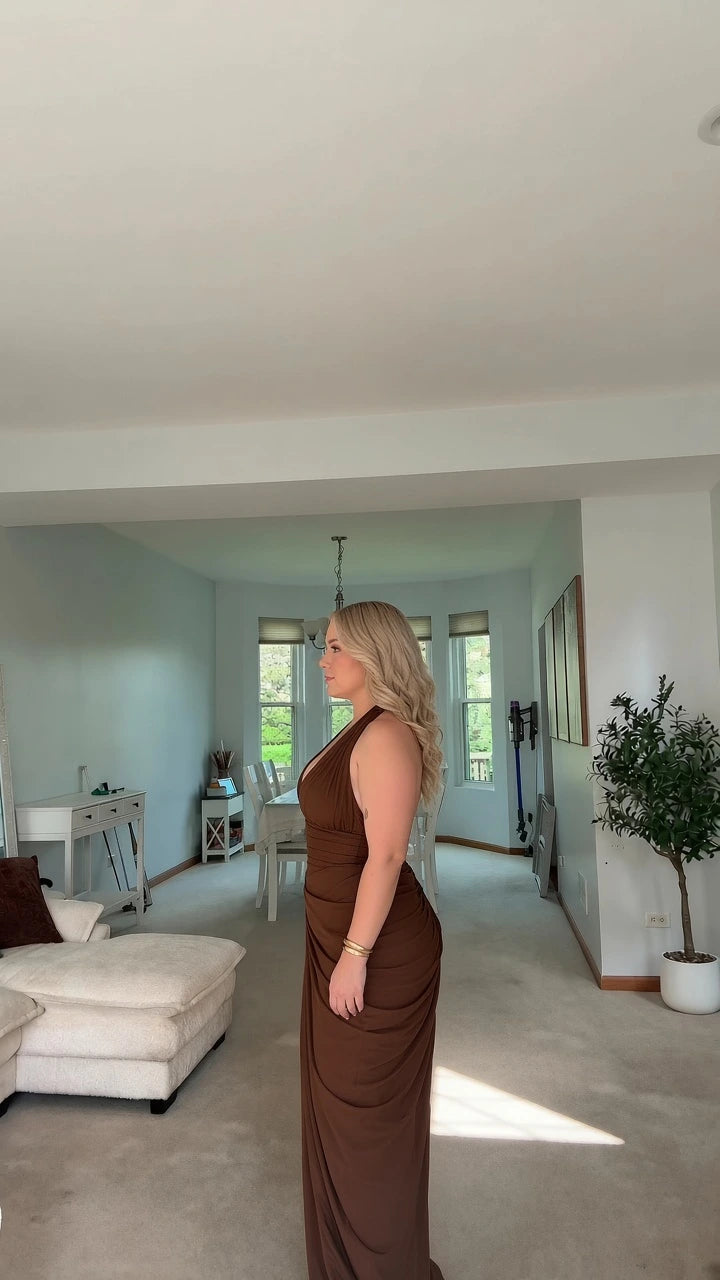 Side profile view of woman wearing brown halter neck maxi evening gown