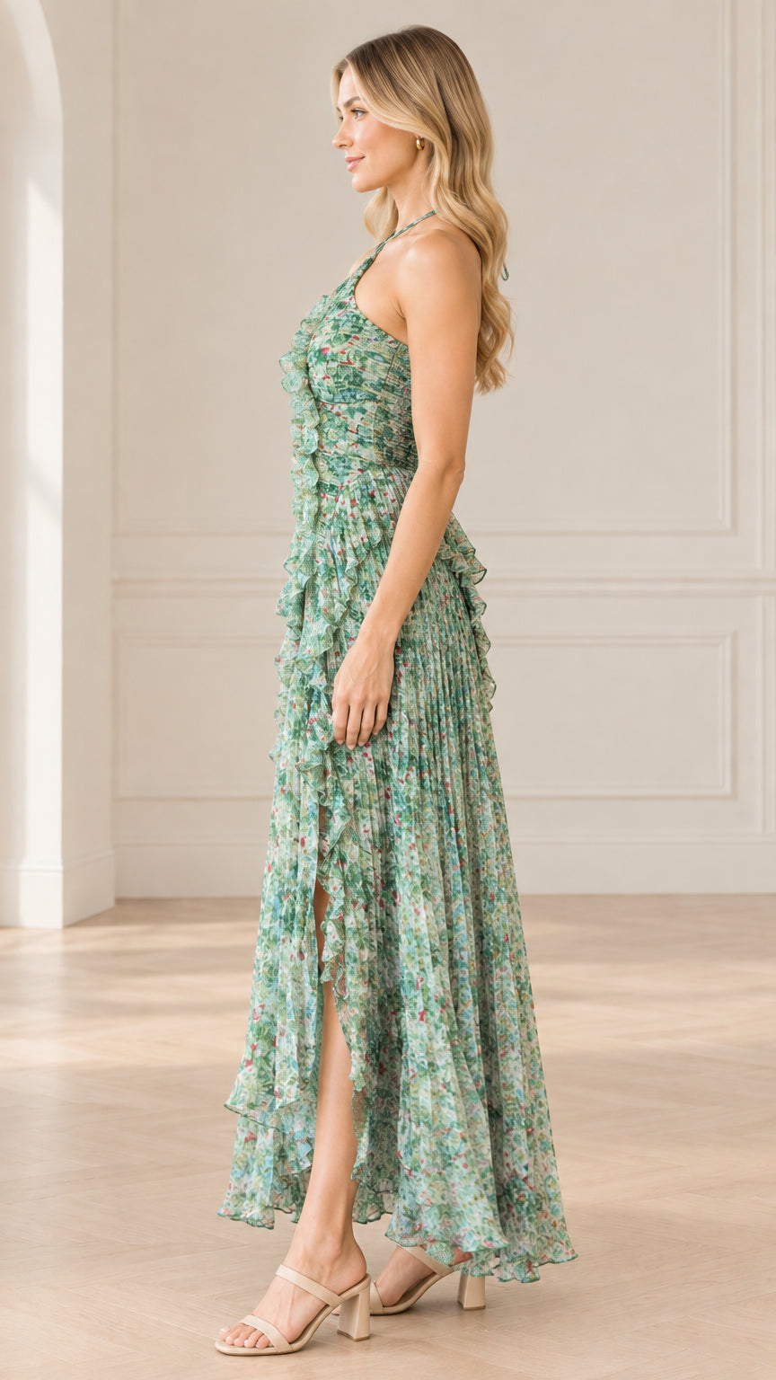 Side profile of model in sage green floral pleated maxi dress highlighting side slit and ruffle detail