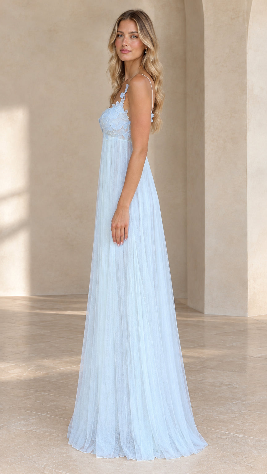 Side profile of model in light blue tulle maxi evening dress showing flowing silhouette