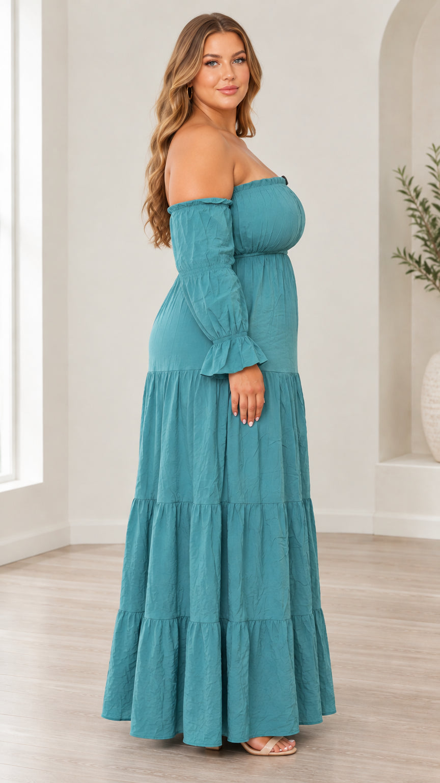 Side profile of model wearing teal off-the-shoulder tiered maxi dress