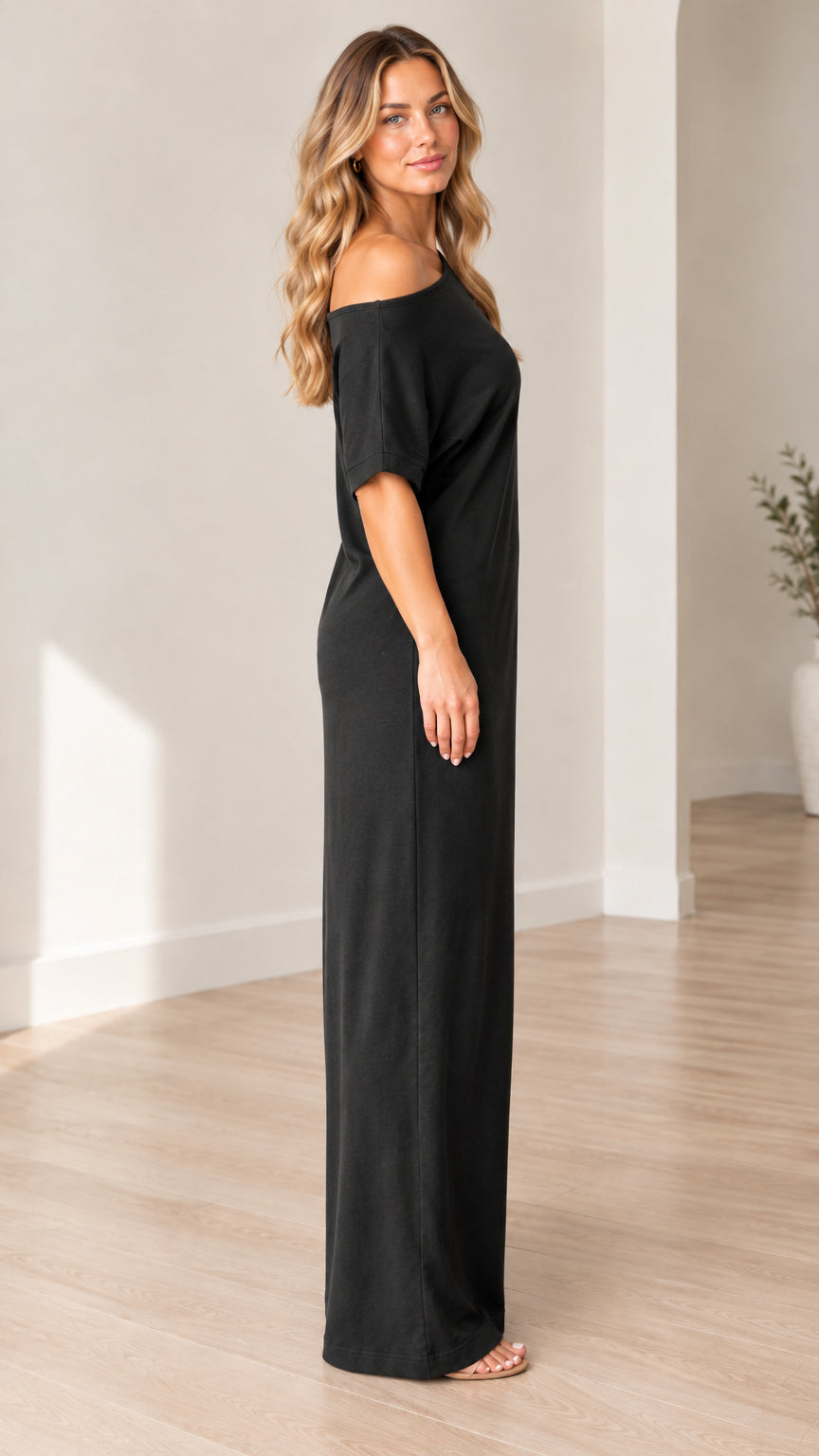 Side profile view of woman wearing black off-the-shoulder maxi dress