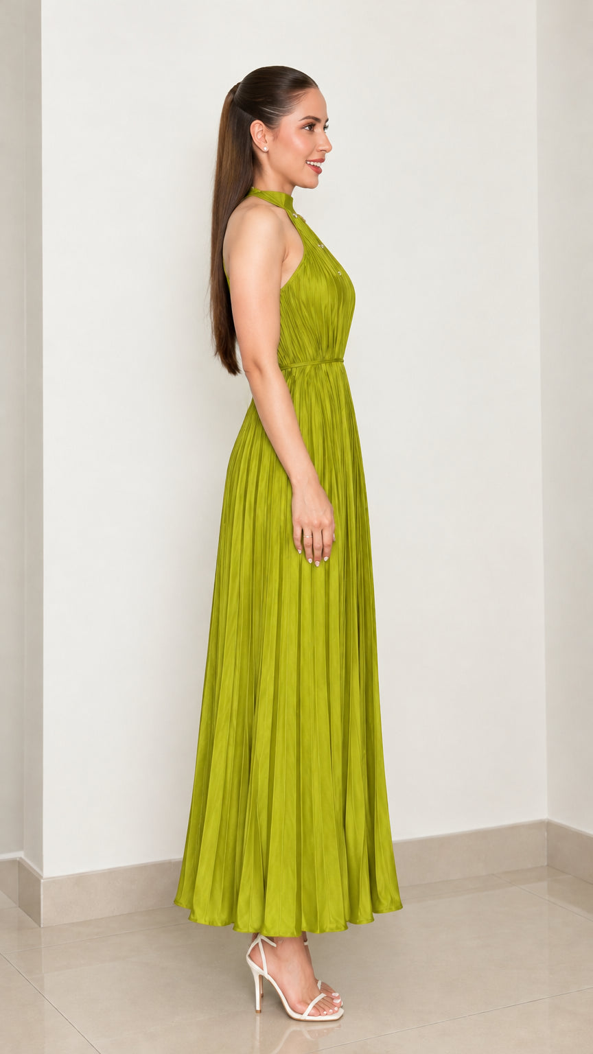 Side profile view of woman wearing chartreuse green pleated sleeveless maxi dress