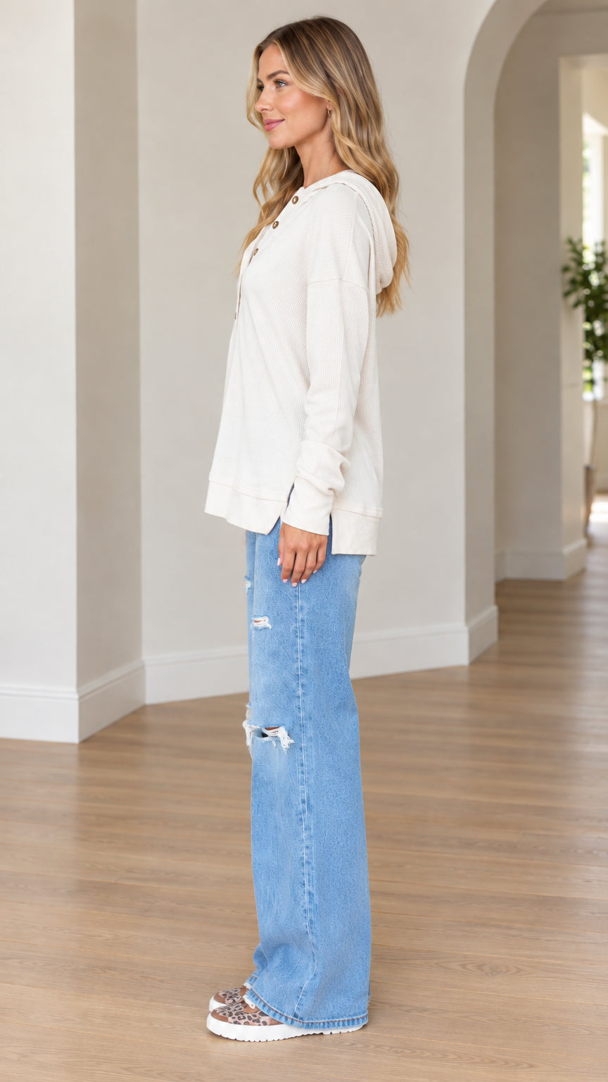 Side full-length view of model wearing cream long sleeve henley hoodie