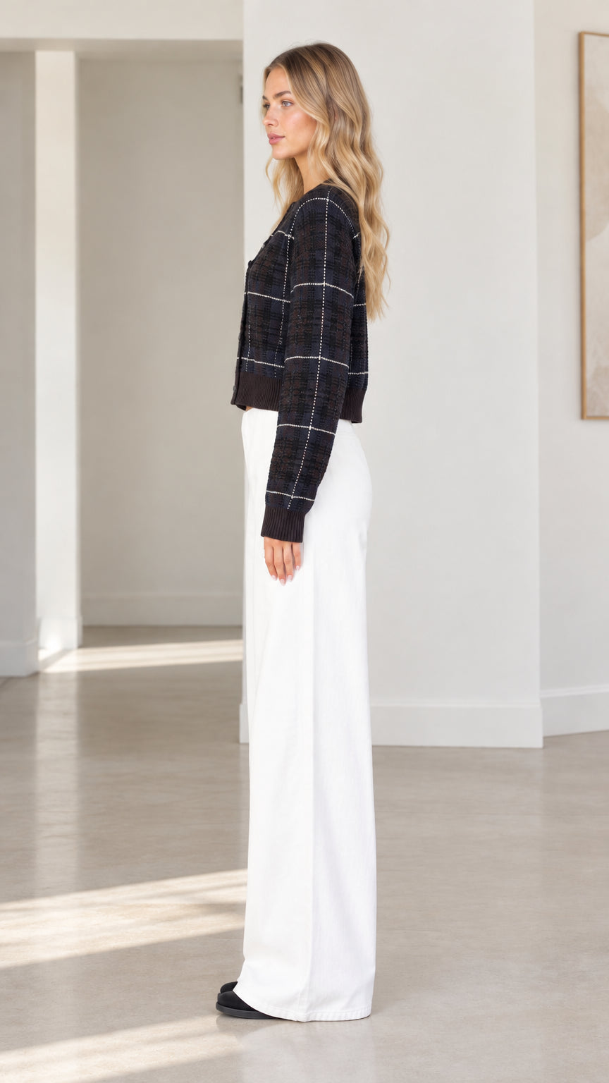 Side profile view of woman wearing black plaid cropped cardigan sweater