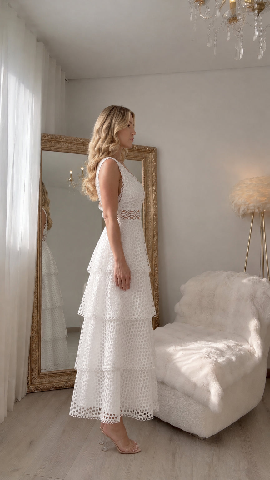 Side profile view of woman wearing white tiered eyelet lace dress