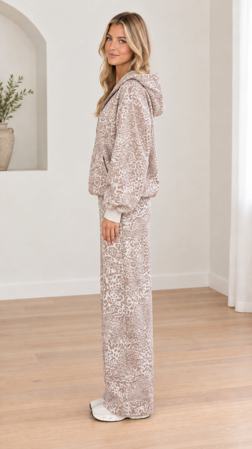 Side profile view of woman modeling taupe leopard print casual tracksuit set