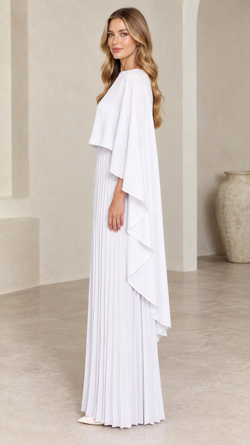 Side profile view of woman wearing white pleated cape maxi dress