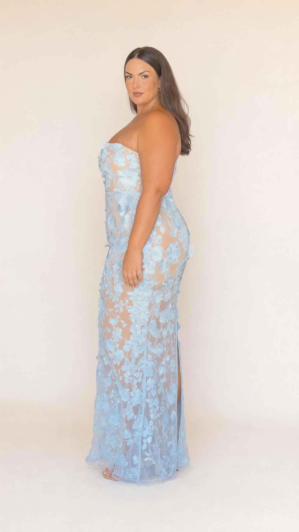 Side profile of model wearing light blue strapless floral lace gown