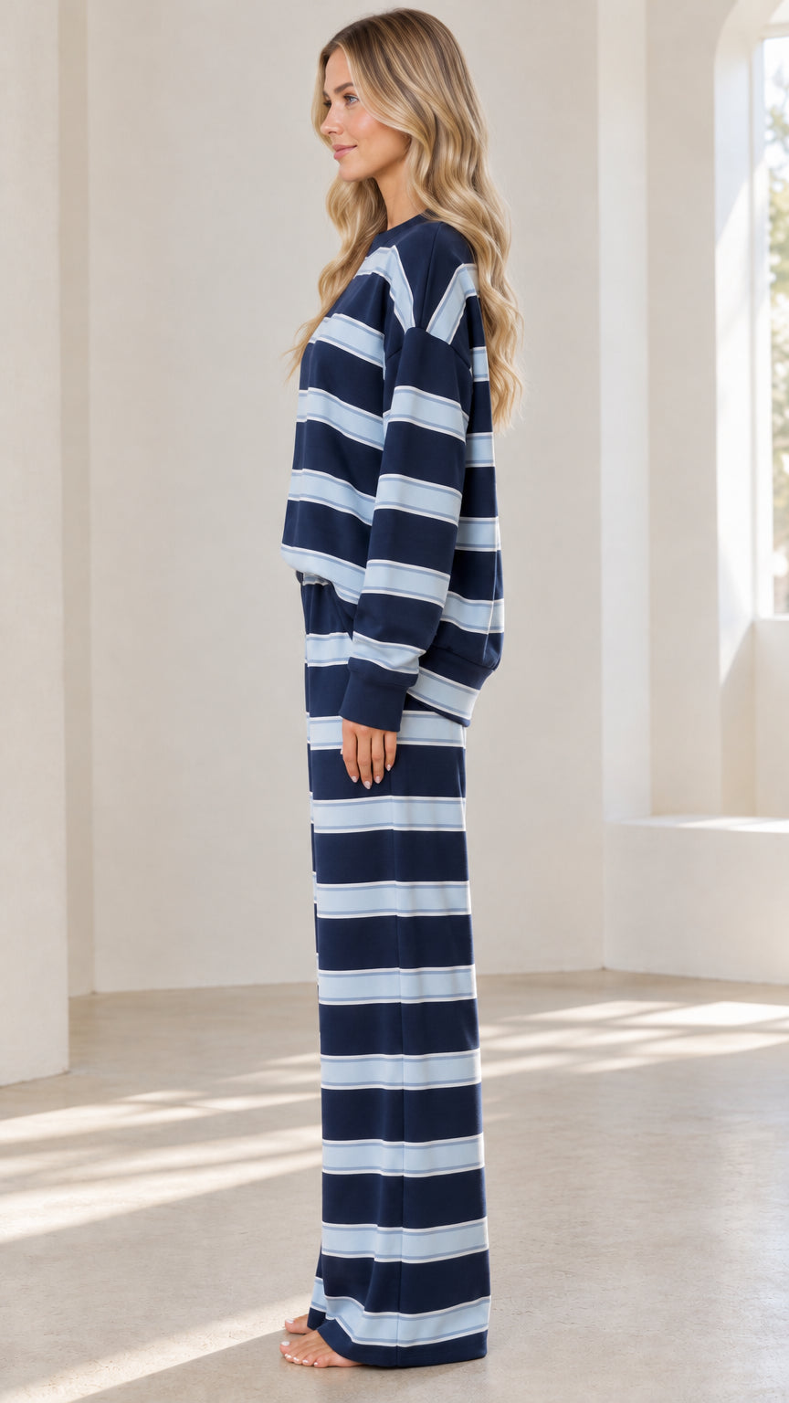 Side profile view of model wearing Navy Blue striped two-piece loungewear set