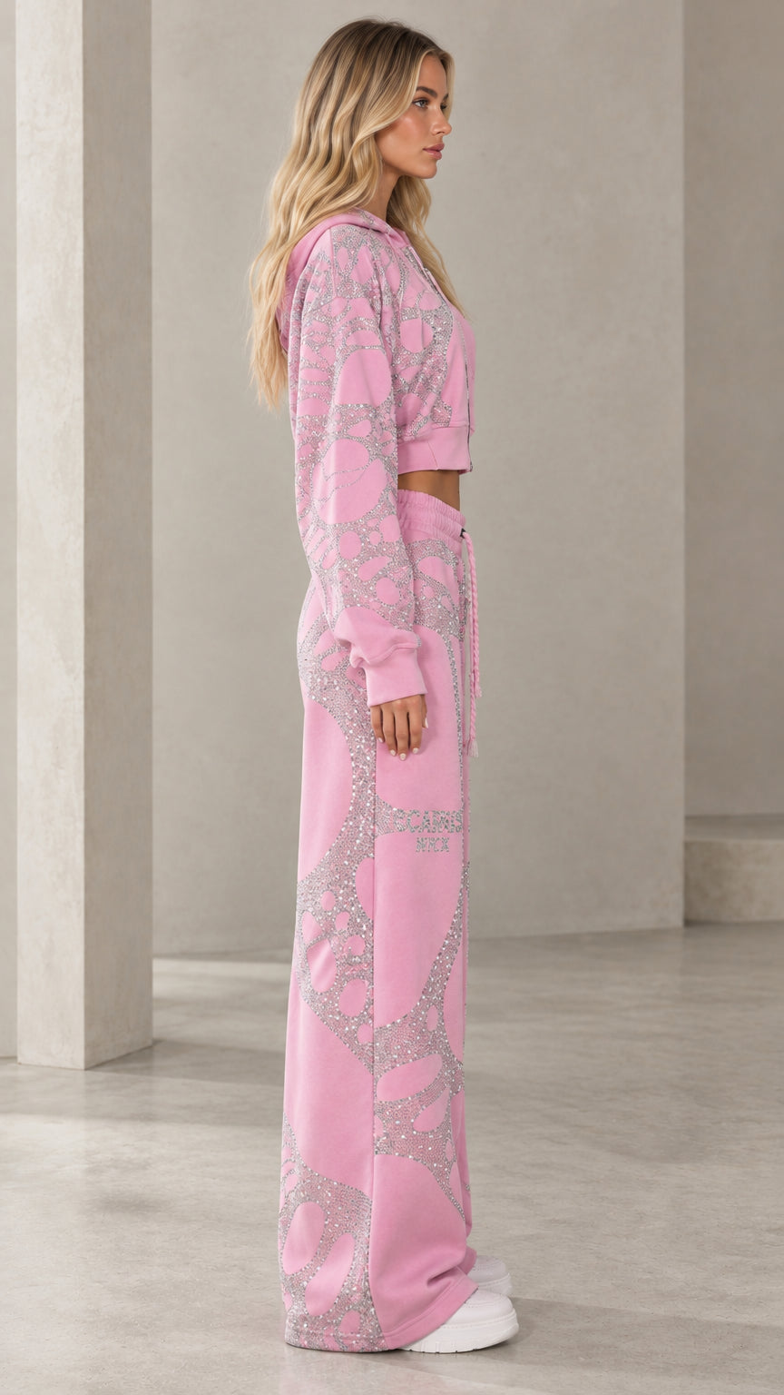 Side profile of model in pink rhinestone cropped zip hoodie and wide-leg trousers