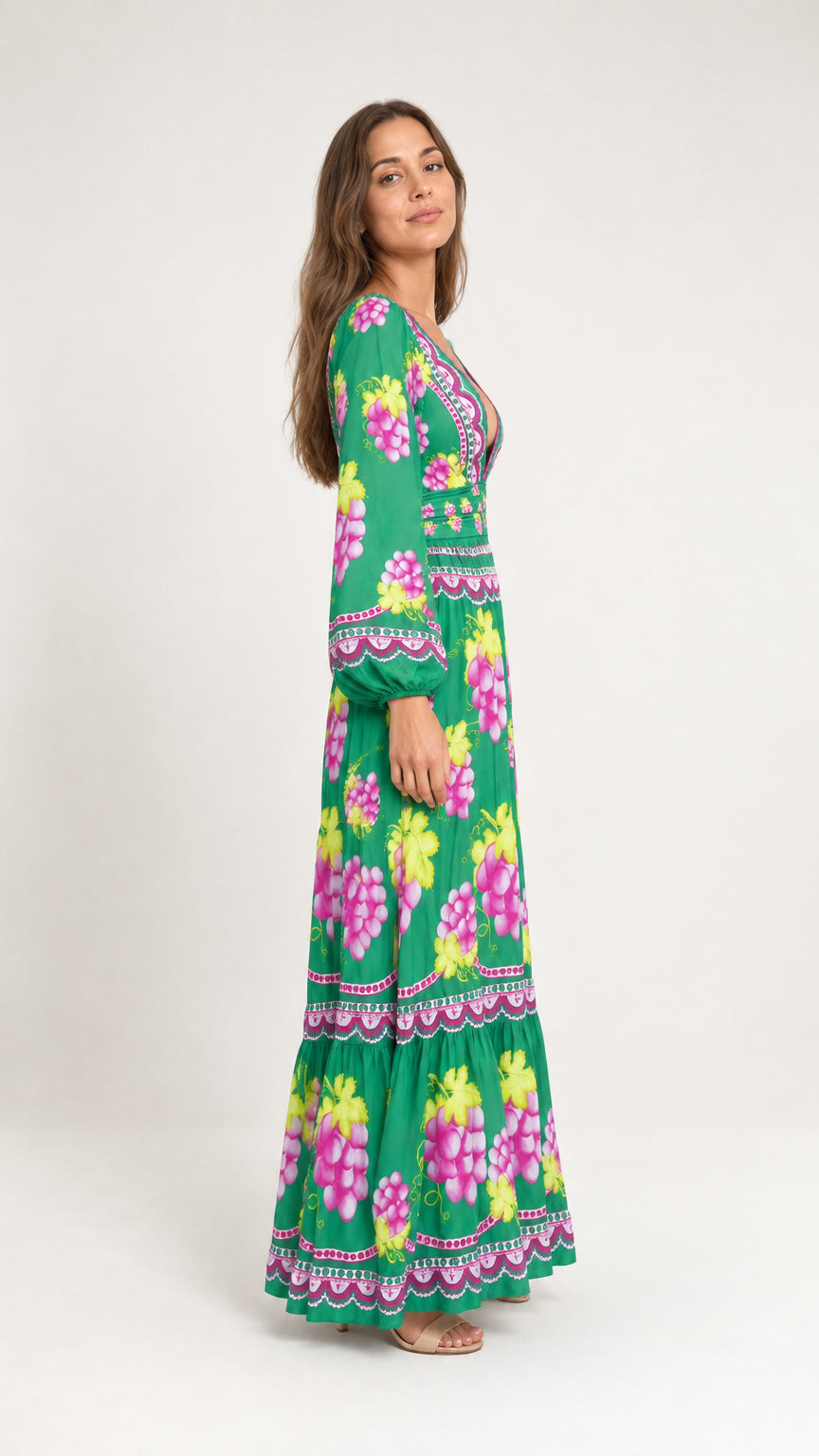 Side profile of woman in green grape print long sleeve tiered maxi dress