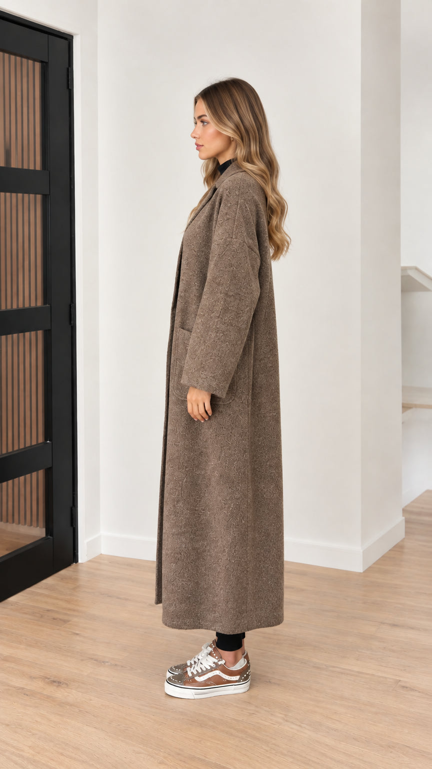 Side profile view of taupe brown maxi overcoat showing relaxed fit and length