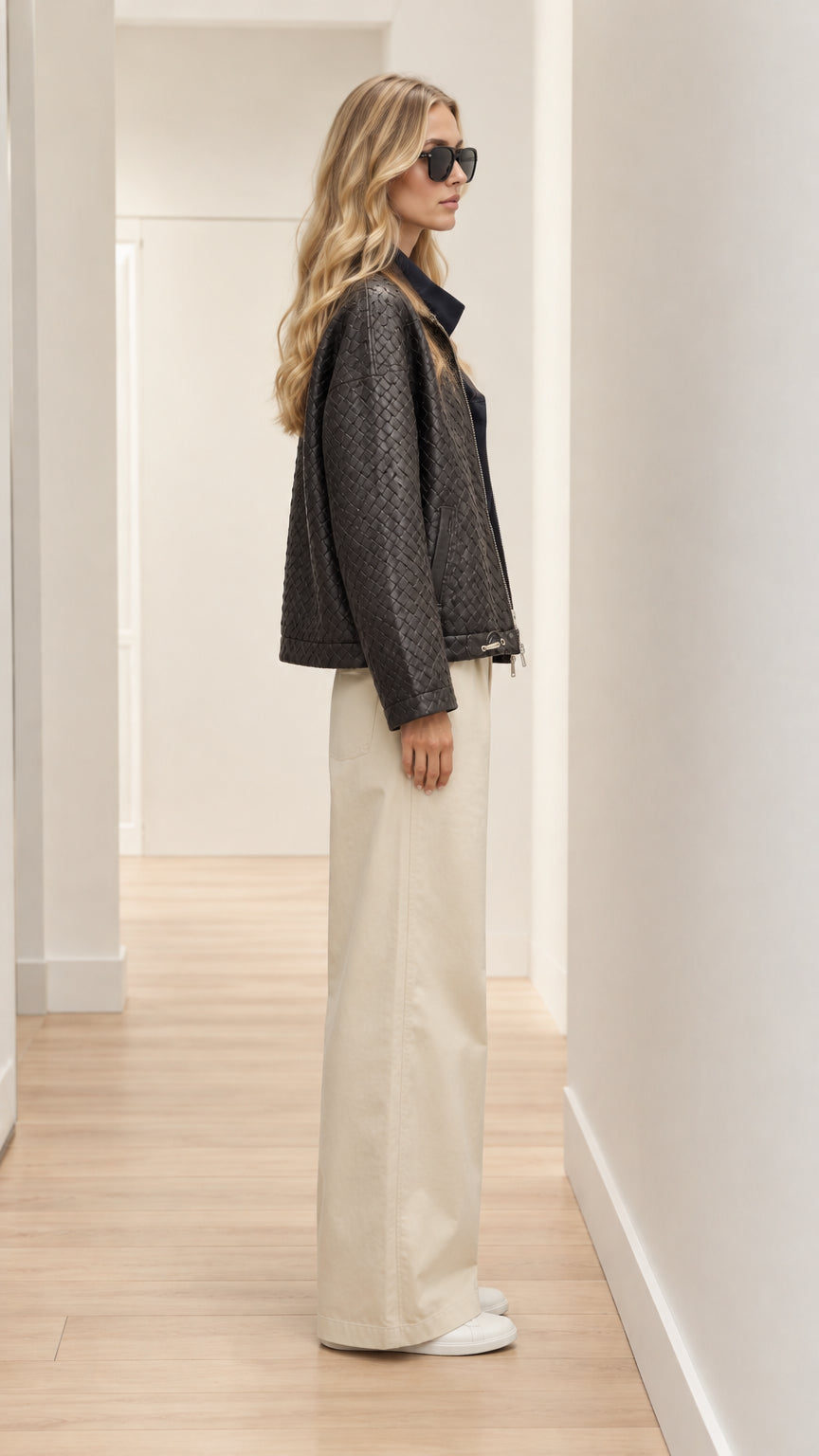 Side profile view of model wearing black woven textured jacket