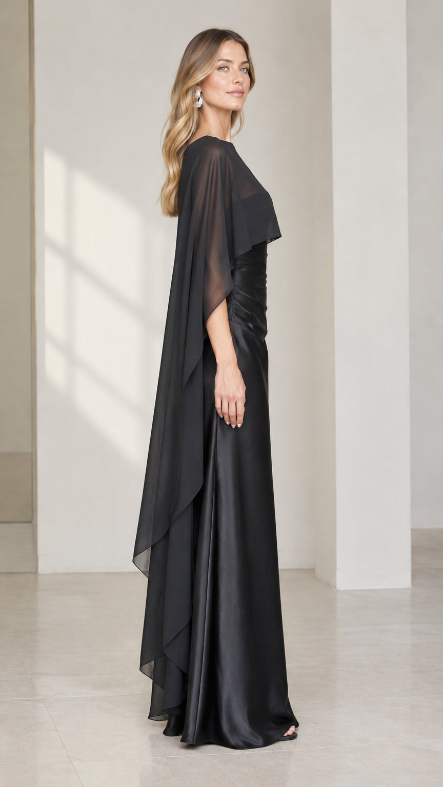 Side profile view of black formal satin maxi gown and sheer cape