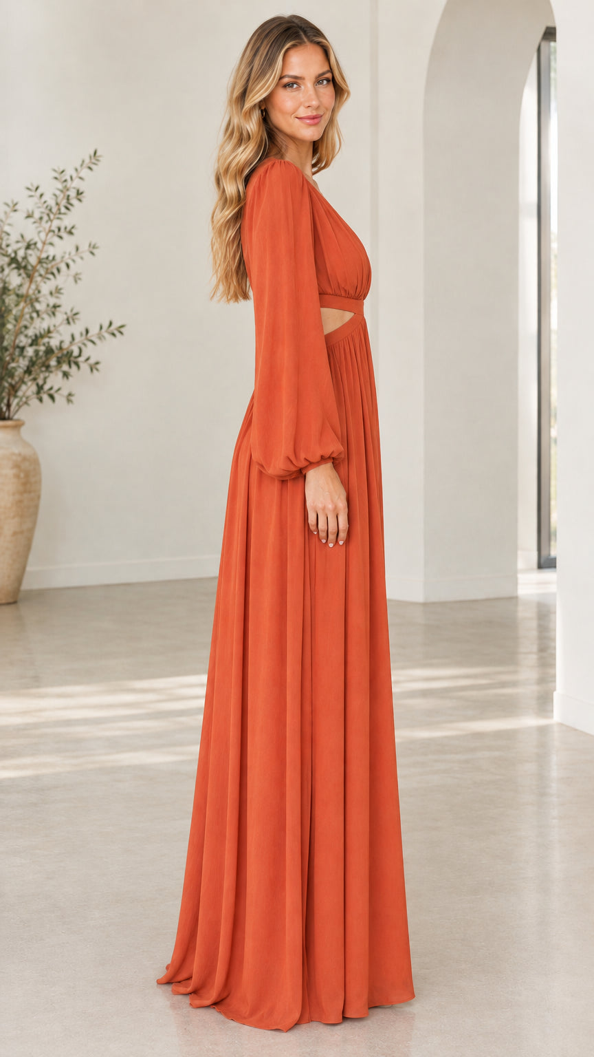 Side profile of woman wearing rust orange long sleeve cutout maxi dress