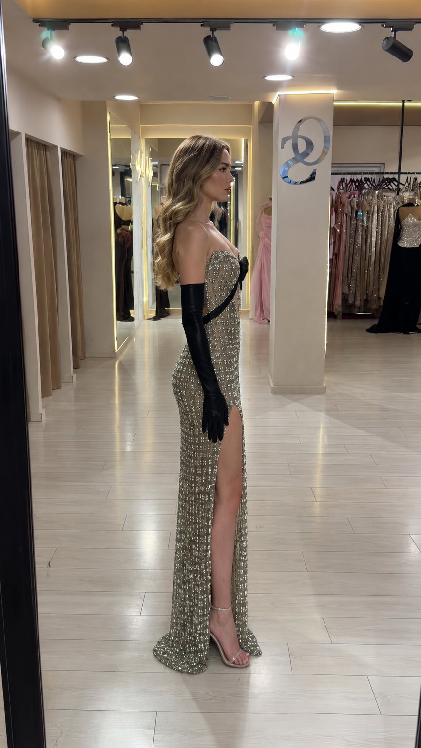 Side profile view of champagne crystal grid formal maxi dress with high leg slit