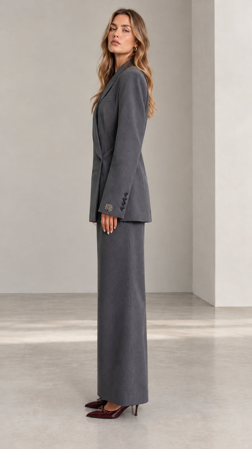 Side profile view of woman wearing Charcoal Grey blazer and maxi skirt suit