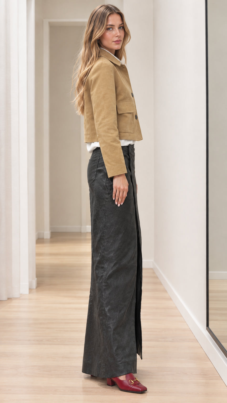 Side profile of woman modeling tan cropped button jacket paired with high-waisted skirt