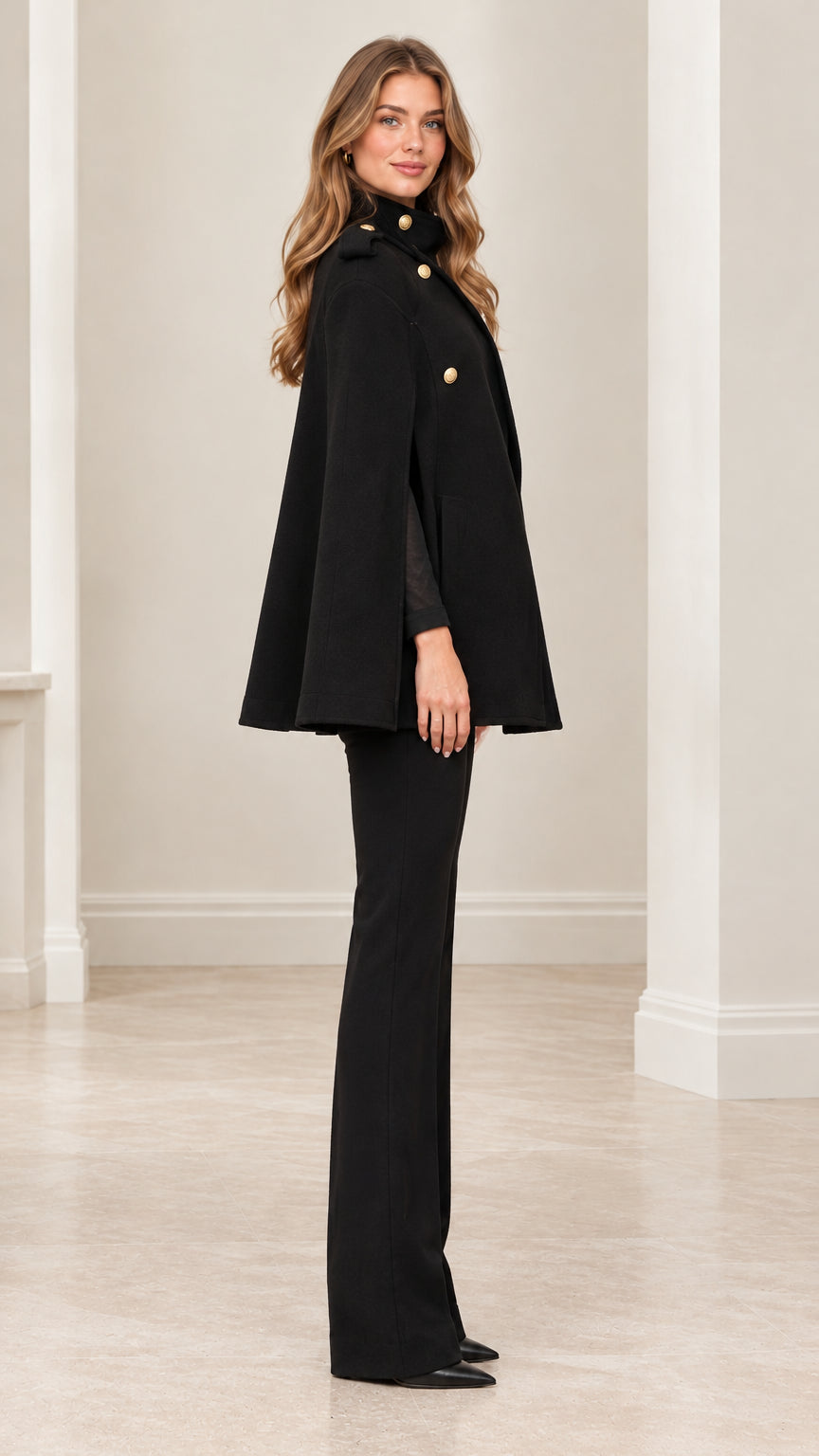 Side profile view of black military buttoned cape coat showing tailored cape drape