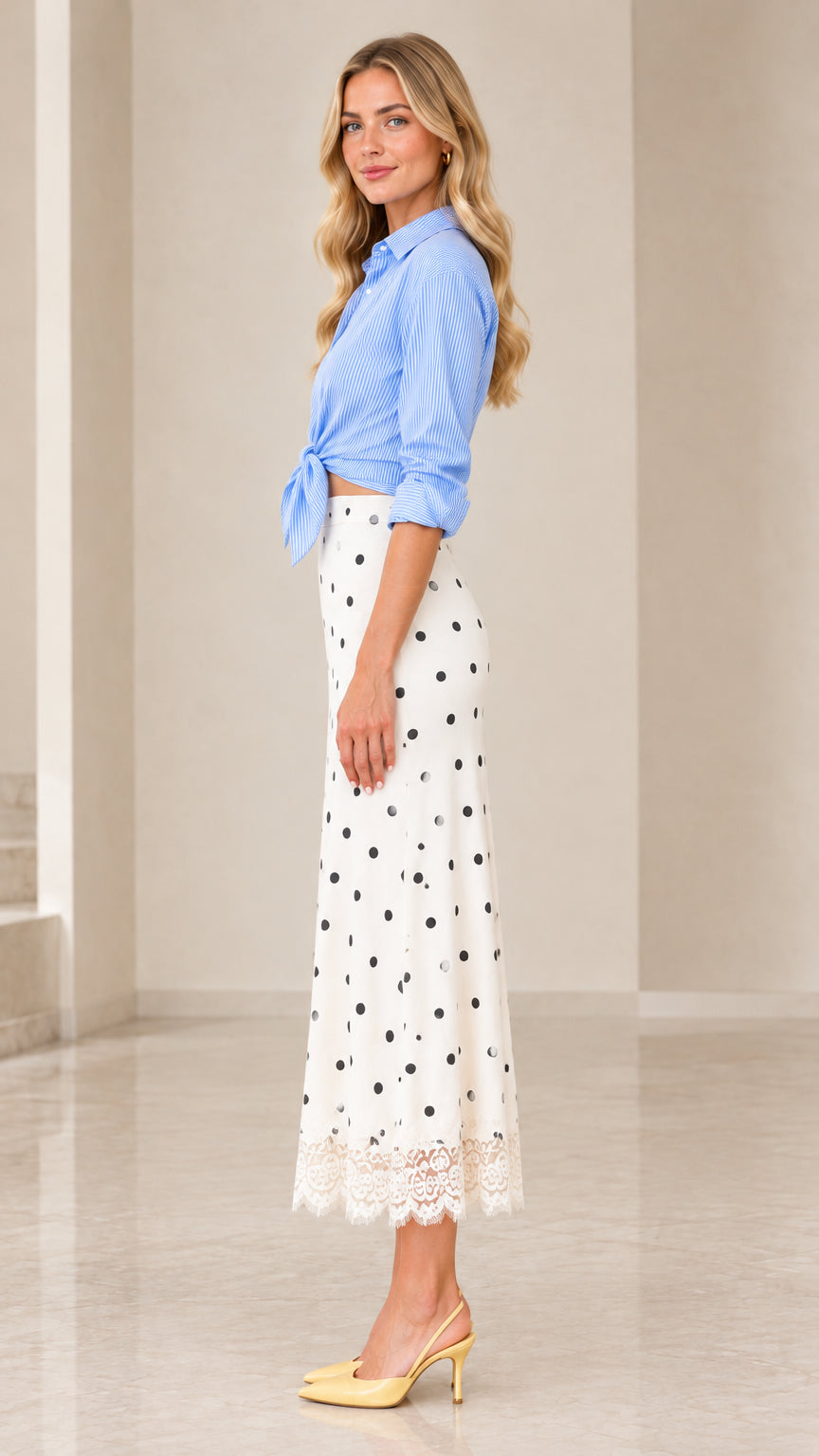Side profile view of woman wearing striped tie-front top and high-waisted white polka dot skirt